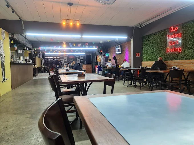 Área interna do Vista Bar em Cajamar com mesas, telão e iluminação ambiente